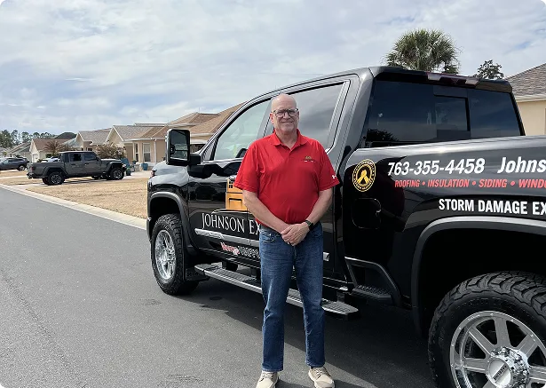Bryan Johnson standing beside a Johnson Exteriors truck