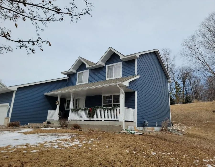 Minnesota two-story home in late winter with a white downspout at the porch, a Johnson Exteriors exterior project