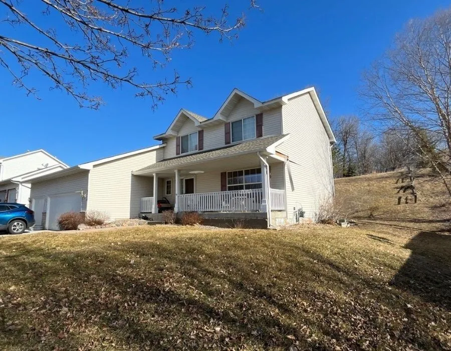 Two-story home with a covered front porch, photographed before a Johnson Exteriors exterior project