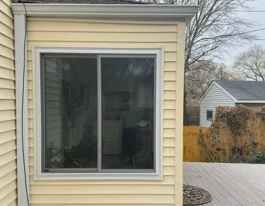 Yellow siding and roof edge with gutter on a Johnson Exteriors exterior project